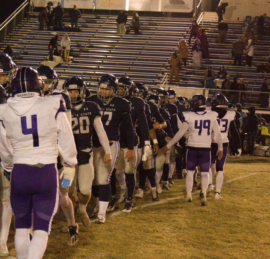DSU Football team lining up to shake the opposing team's hand.