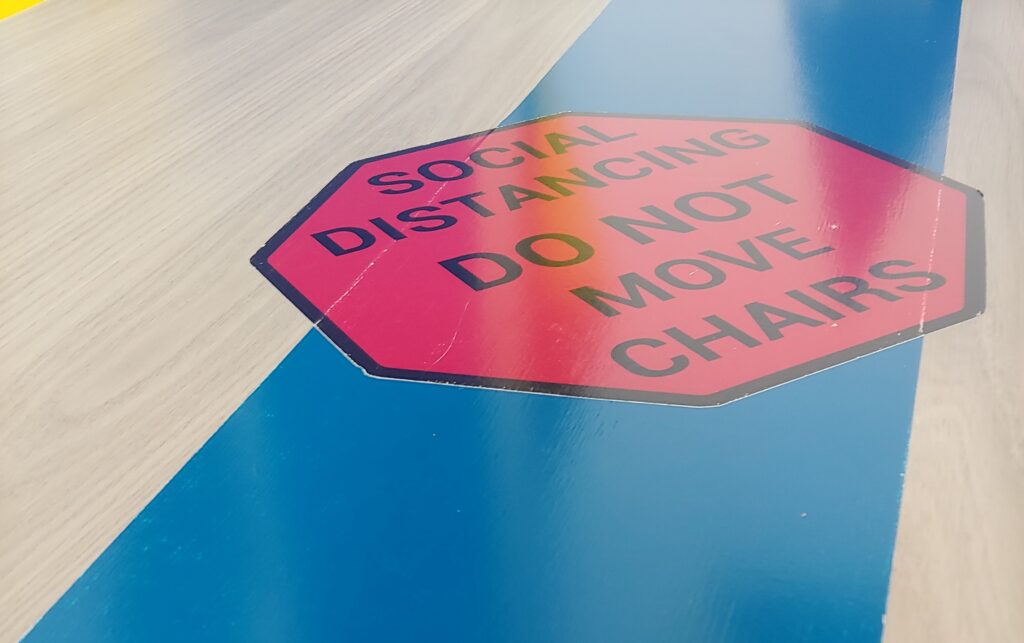 sign saying "social distancing do not move chairs"