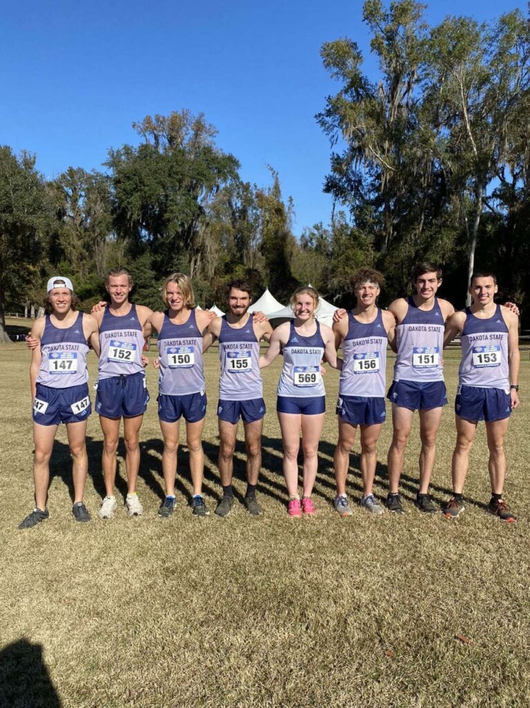 Cross Country team standing side by side in Trojan uniform.