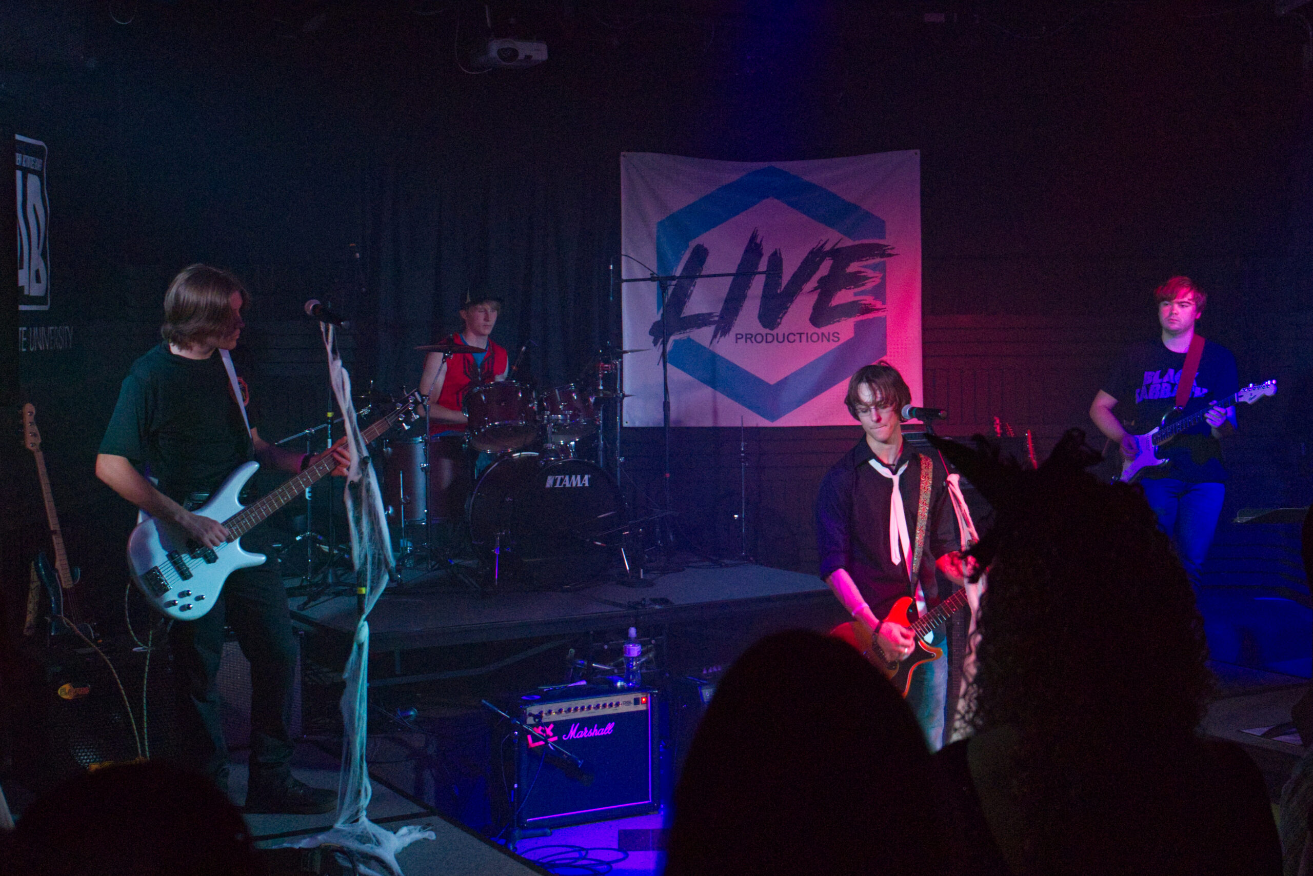 4 men playing instruments on a stage