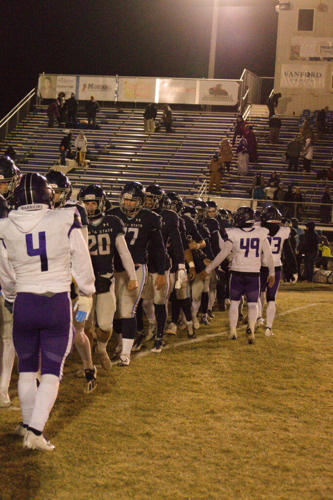 DSU Football team lining up to shake the opposing team's hand.